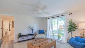 A modern living room with a sofa, coffee table, and a view of the outdoors through large windows. - This house is a 3 bedroom(s), 2 bathrooms, located in Marion, IN. (Marion)