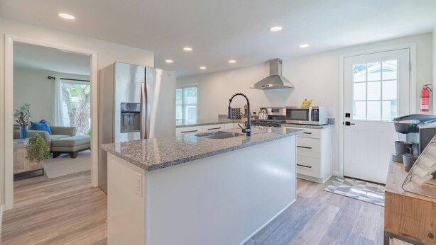 A modern kitchen with a central island, stainless steel appliances, and a large window providing natural light. - This house is a 3 bedroom(s), 2 bathrooms, located in Marion, IN. (Marion)