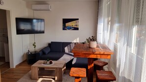 A modern living room with a sofa, a coffee table, and a TV mounted on the wall.