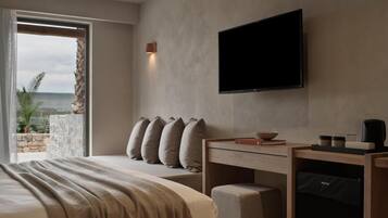 Habitación de hotel moderna con una cama grande, un escritorio con silla, televisor de pantalla plana y vistas al exterior.