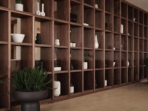 Una estantería de madera con varios objetos decorativos y plantas.