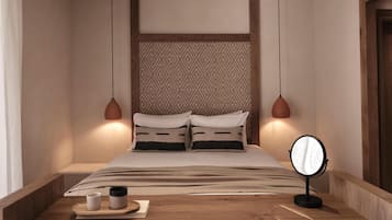 Un dormitorio ordenado con cama, mesita de noche y espejo.