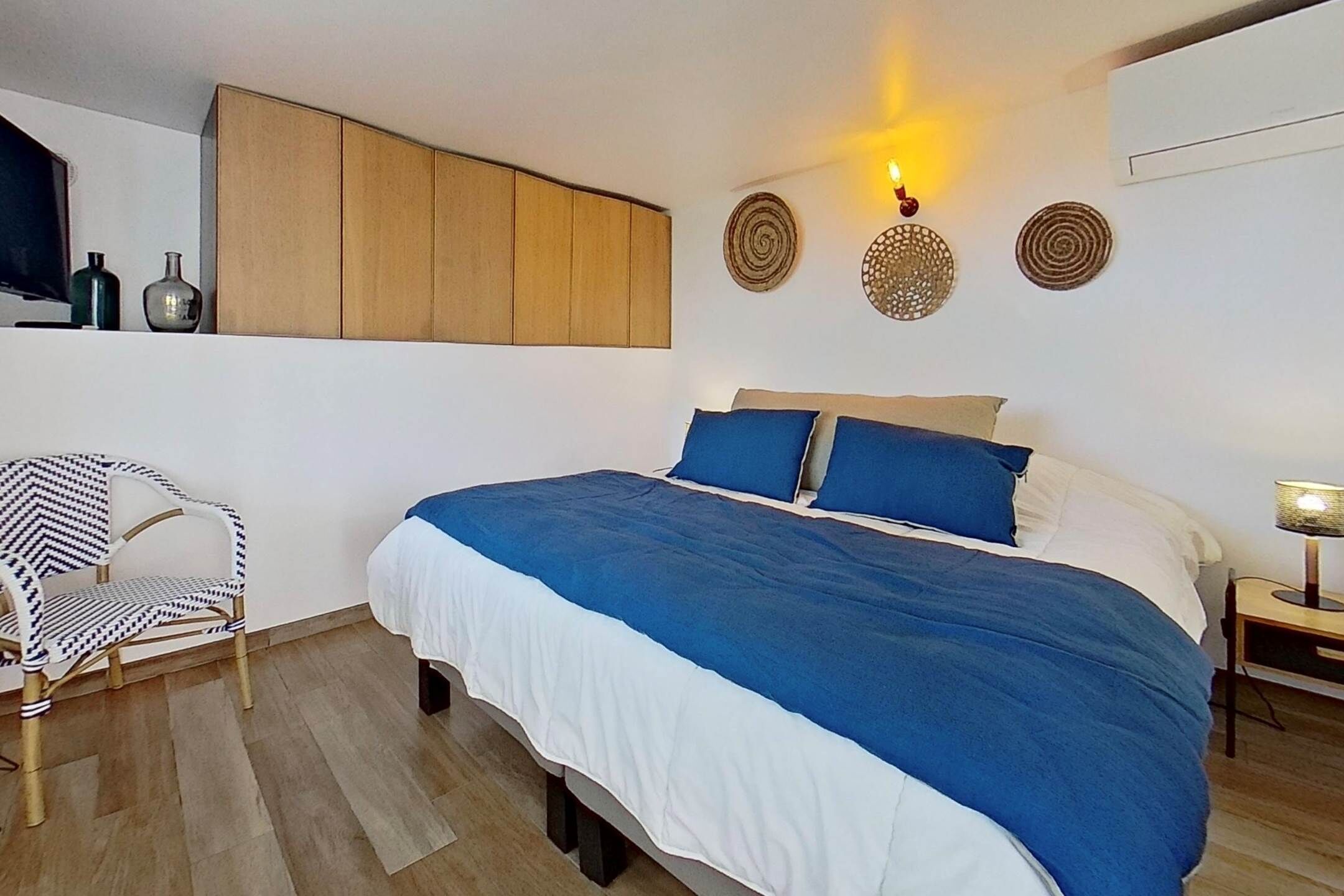 Ein Schlafzimmer mit einem Bett, einem Sessel und Wanddekoration.