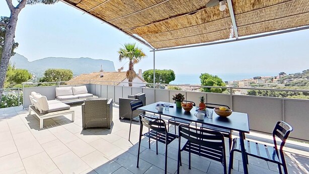 Un patio al aire libre con una mesa, sillas y un sofá.