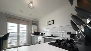 Una cocina moderna con lavadora integrada, estufa y microondas.