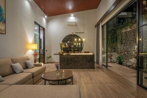 A modern living room with a sofa, a coffee table, and a reception desk.