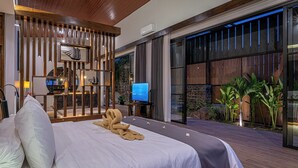 A modern bedroom with a large bed, a television, and a view of the outdoors.