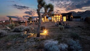 A desert-style house with a large patio area, a visible guest room, and a sign reading "JOSSA TREE". - The Tree House By The Cohost Company (Joshua Tree)