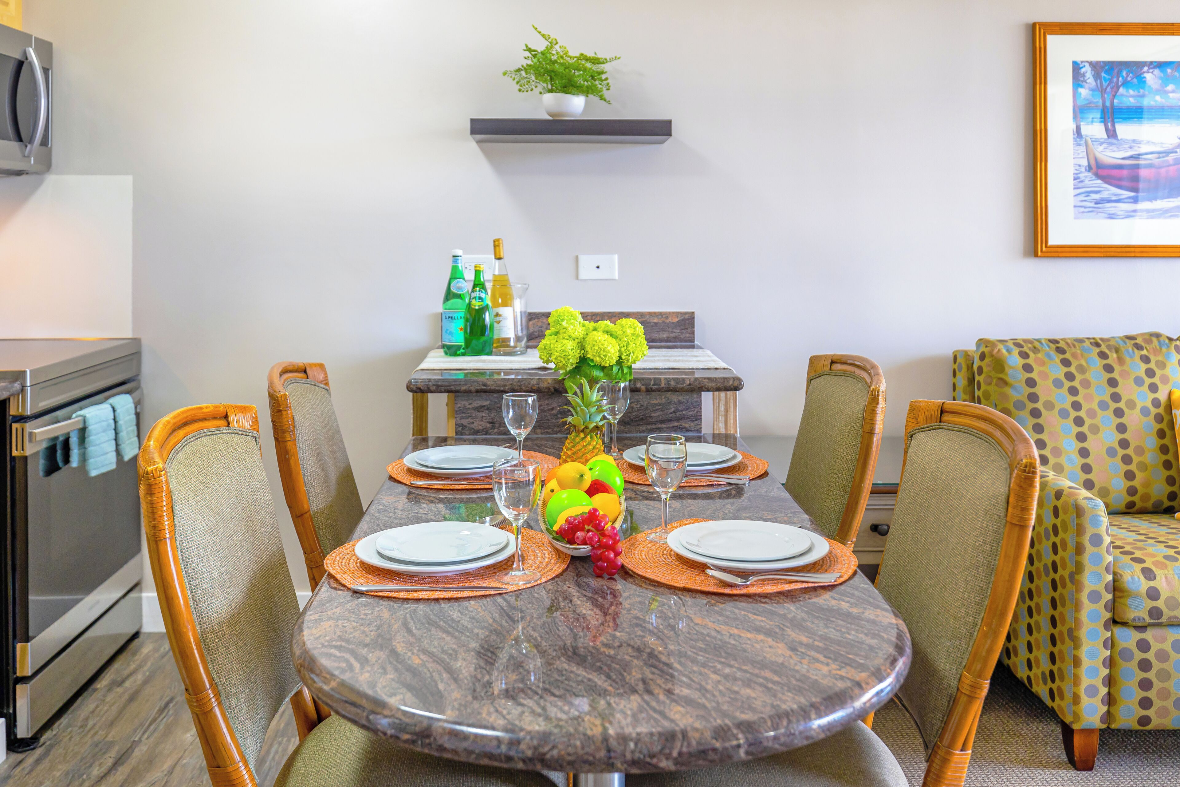A dining area with a round table, chairs, and a fruit centerpiece.