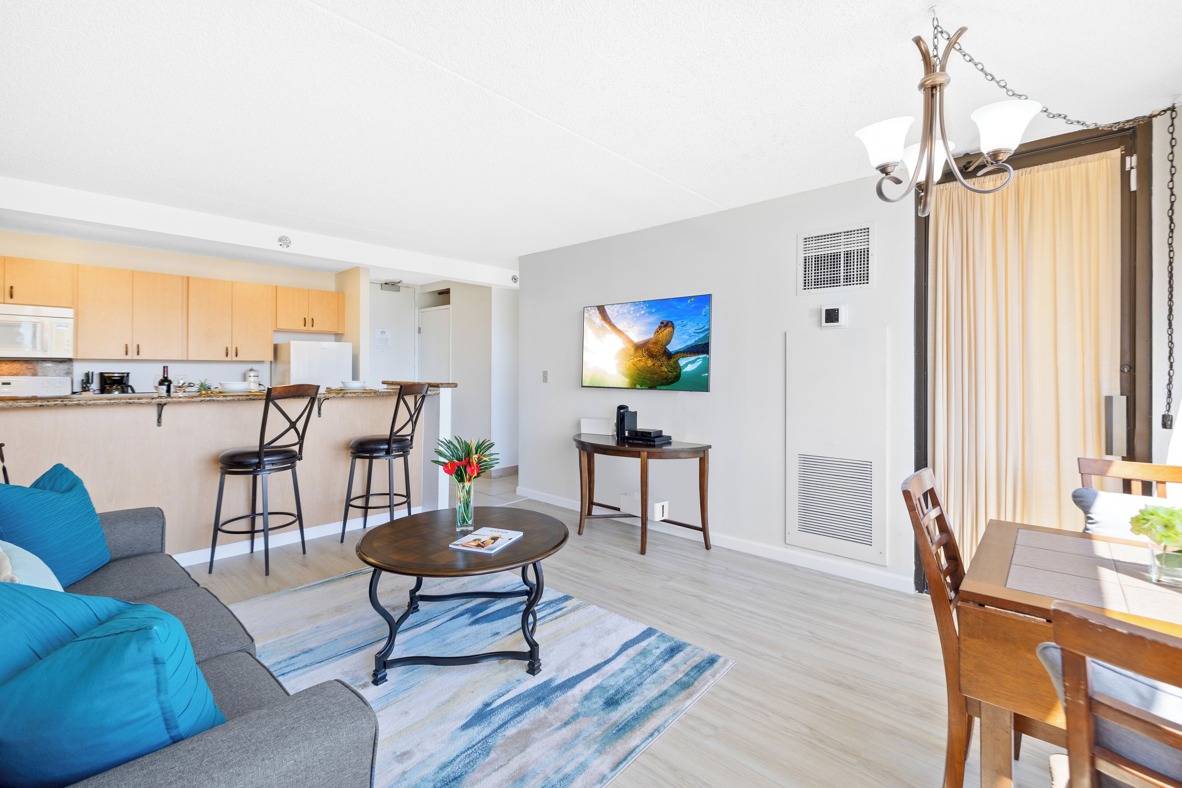 A modern living room with a sofa, coffee table, and dining area.