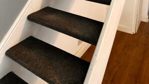 A staircase with wooden handrails and carpeted steps. - Chatham Retreat by the River (Chatham)