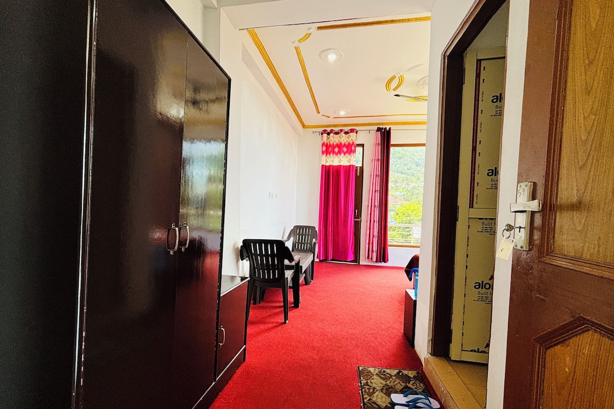 A hallway with a red carpet leading to a room with a bed, a wardrobe, and a door with a lock.