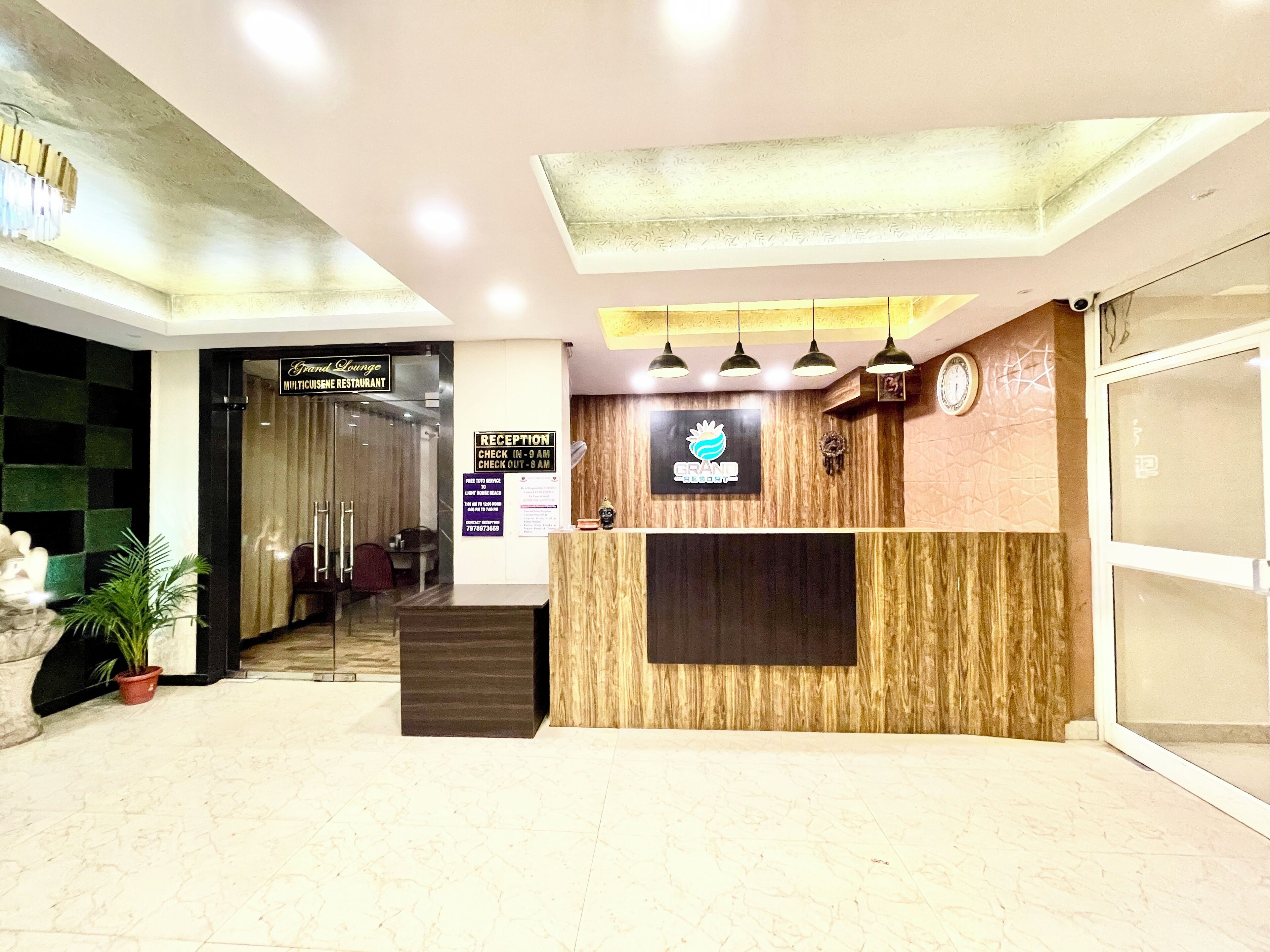 A reception desk with a wooden panel design, a clock, and a sign indicating check-in times.