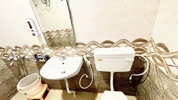 A bathroom with a sink, toilet, and shower area.