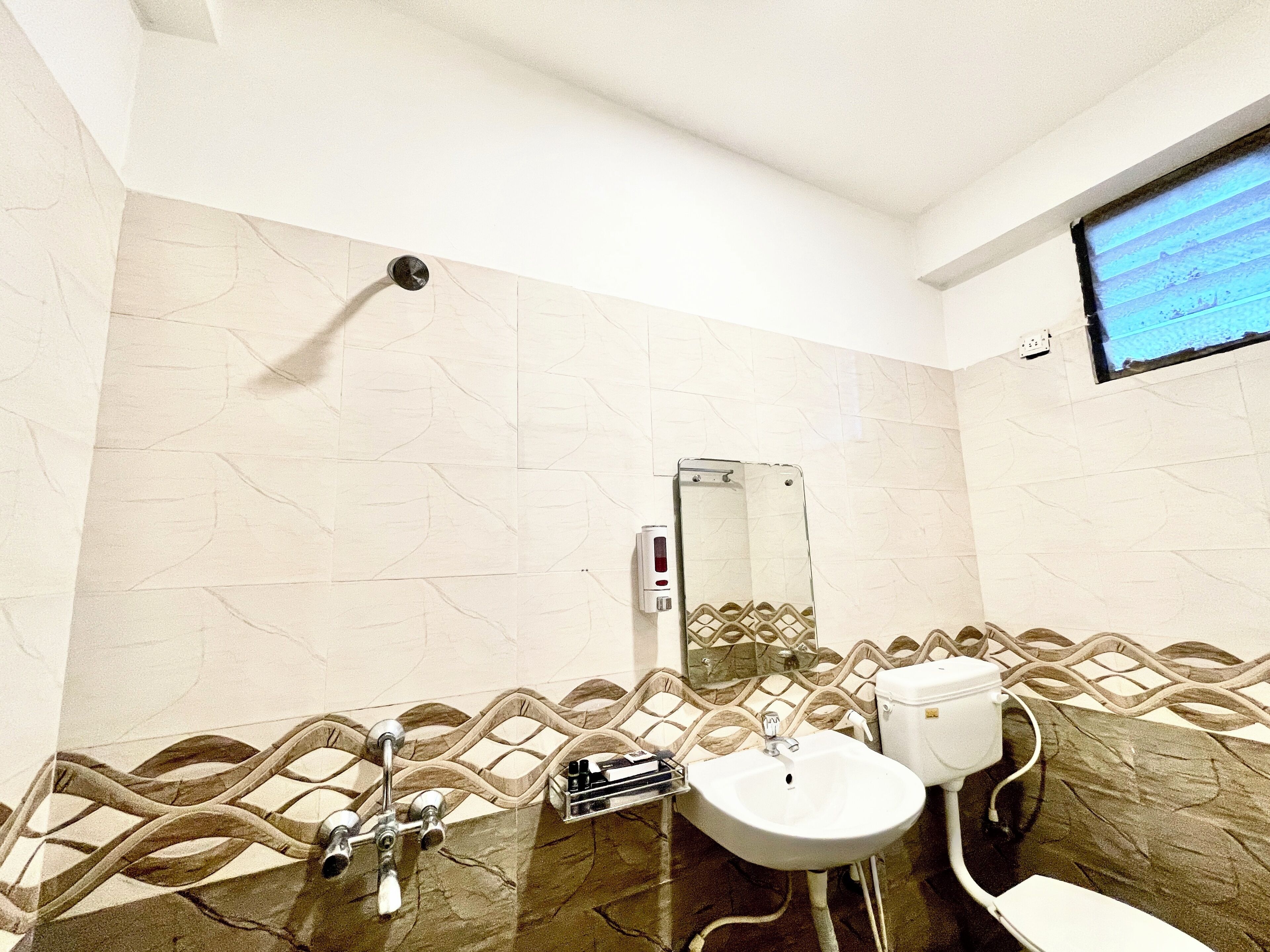 A bathroom with a white sink, a toilet, and a mirror.