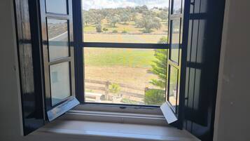 A bathroom with a window overlooking a garden.