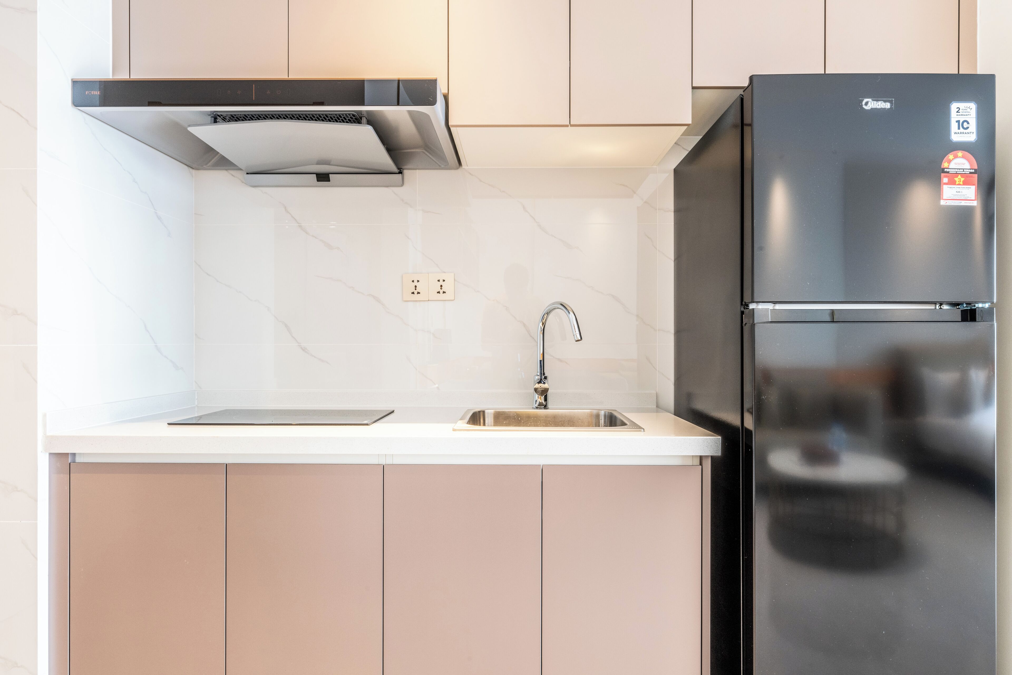 Eine moderne Küche mit einem Edelstahlkühlschrank, einem Backofen und einem Spülbecken.