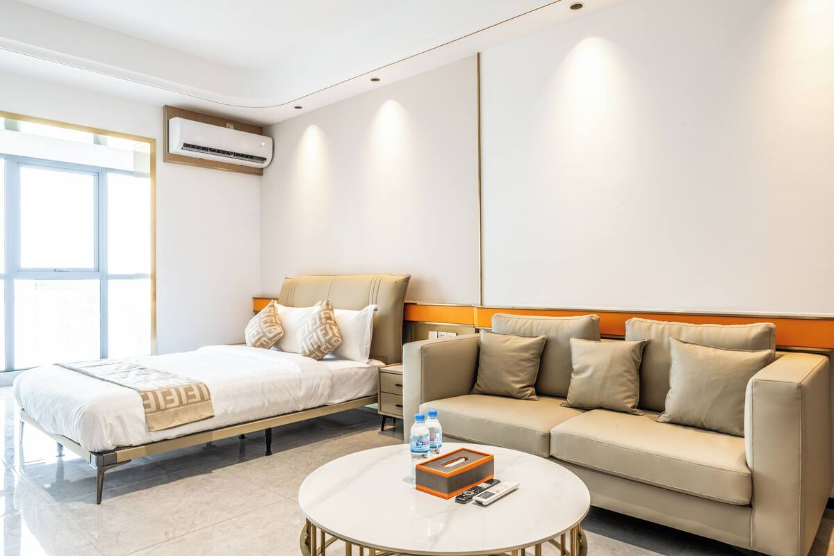 Une chambre d’hôtel équipée d’un lit, d’un canapé, d’une table basse et d’un appareil de climatisation.
