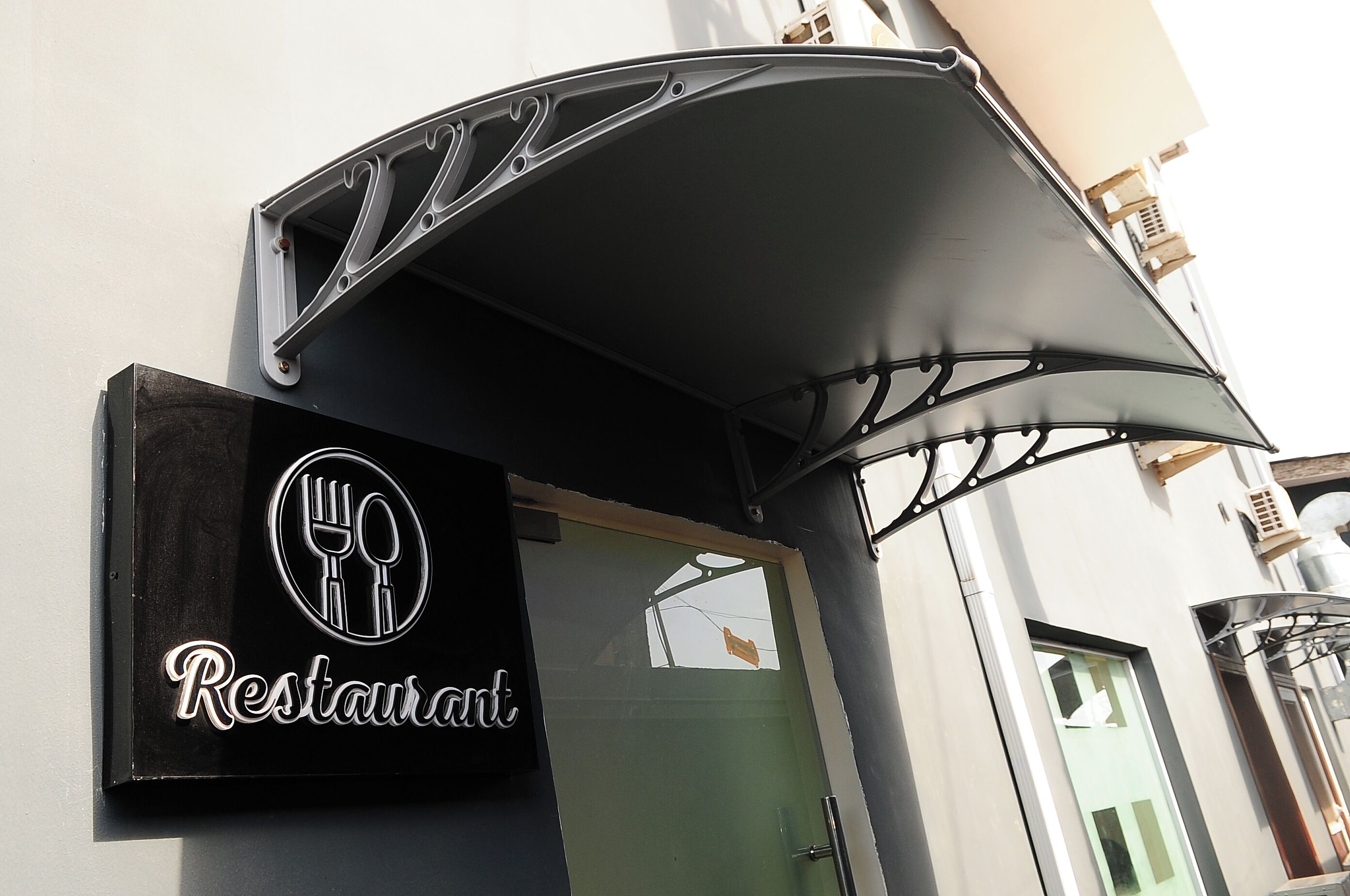 Ein Restaurantschild mit dem Logo einer Gabel und eines Messers, darunter das Wort 'Restaurant'.