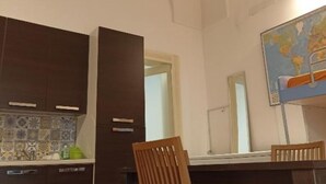A hotel room with a tiled backsplash, a wooden chair, a dining table, and a world map on the wall. - SALENTO SEA AND ART (Nardò)