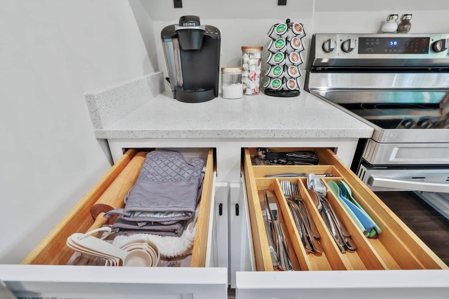 Een keuken met een koffiezetapparaat, een theedispenser en een magnetron. Er zijn lades met keukengerei en een handdoek.