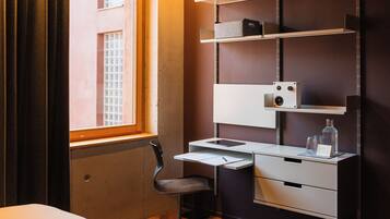 Una habitación de hotel moderna con escritorio, silla y estanterías empotradas.