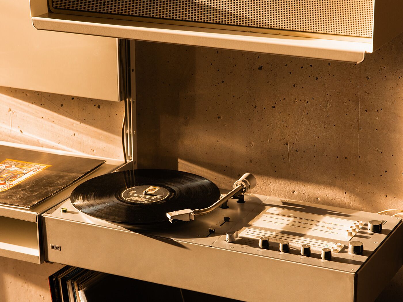 A turntable with a vinyl record, a mixer, and a speaker.