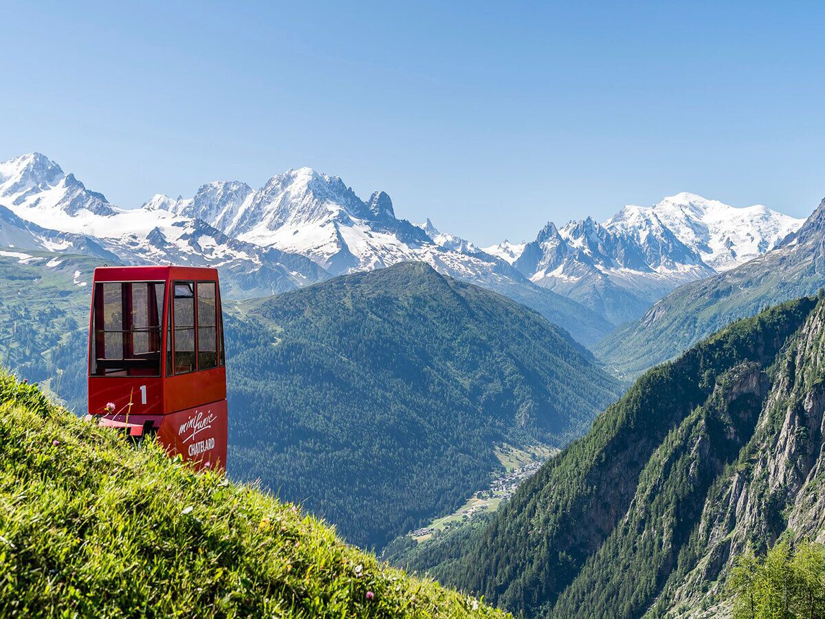 A red cable car with "minifly" and "CHATEAUARD" visible, set against a mountainous backdrop.