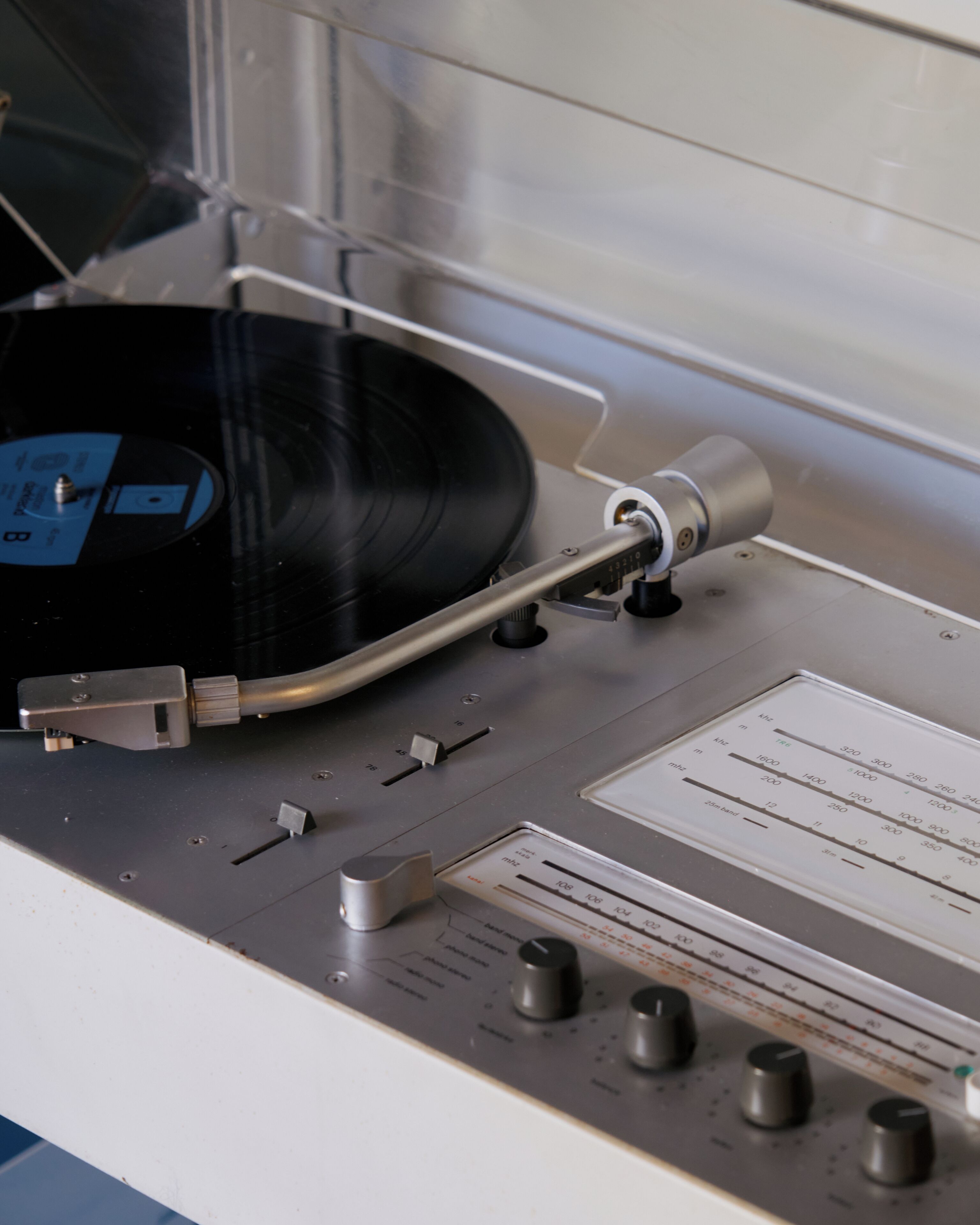 A turntable with a vinyl record, control knobs, and a label with measurement markings.