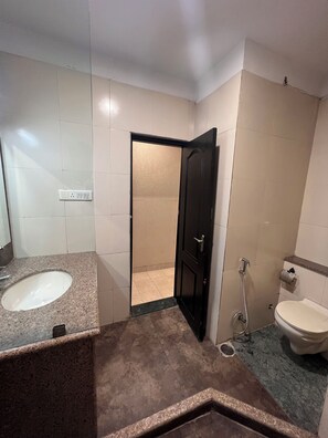 A bathroom with a sink, toilet, and shower area.