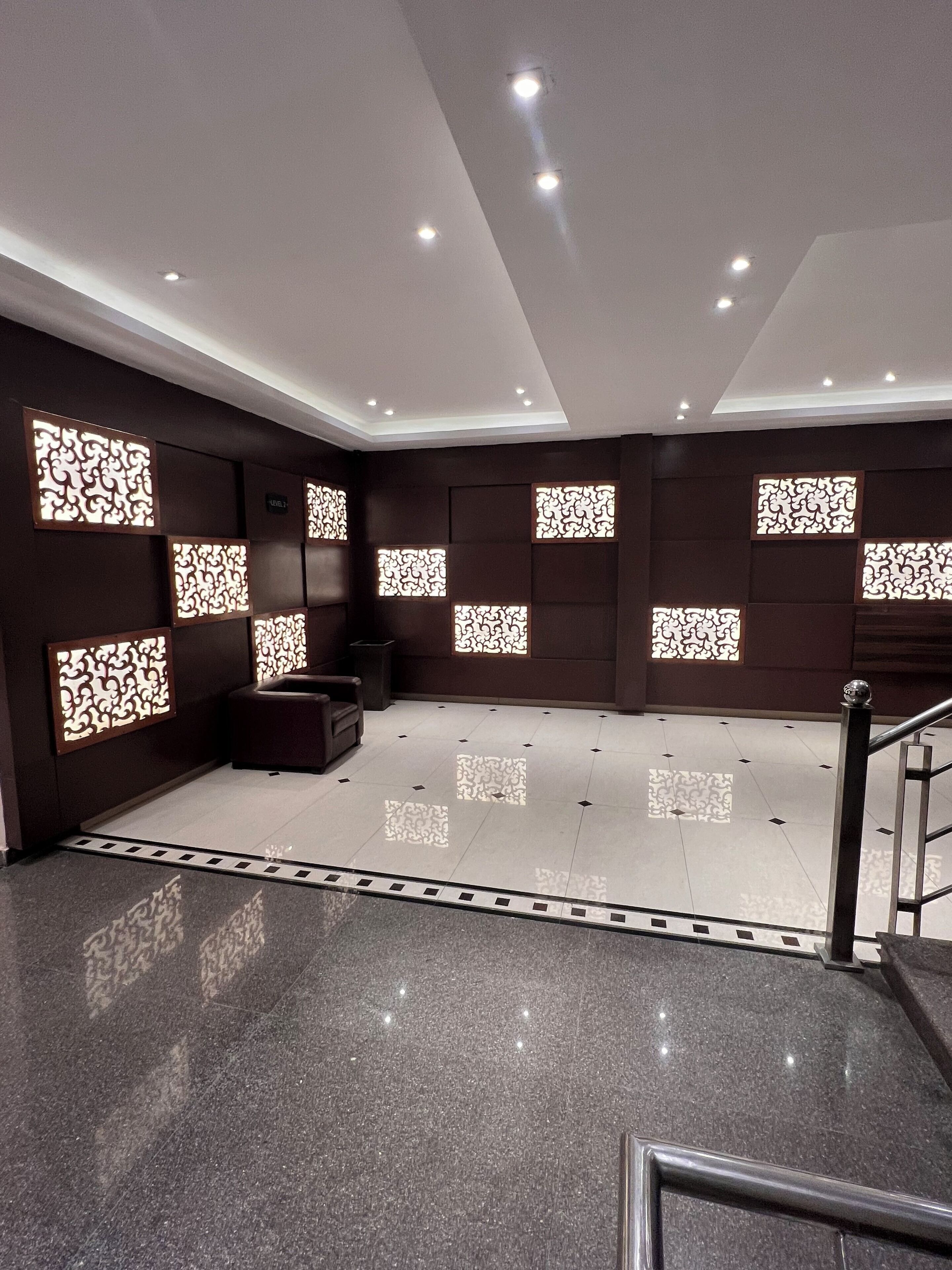 A modern interior with a polished floor, dark walls, and decorative panels.