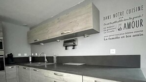 A modern kitchen with a large island, built-in appliances, and a wall-mounted toaster.