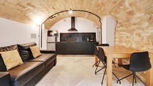 A modern kitchen with a black countertop, a built-in oven, and a hanging light fixture. - An Atypical 1-BR in Place Vendôme Tuileries (Paris)