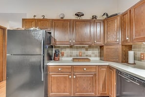 A kitchen with wooden cabinets, a stainless steel refrigerator, and a dishwasher. - Loonsight - PET FRIENDLY (Minocqua)