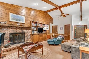 A cozy living room with a fireplace, bookshelves, a television, and comfortable seating. - Loonsight - PET FRIENDLY (Minocqua)