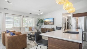 A modern living room with a sofa, coffee table, and dining area.