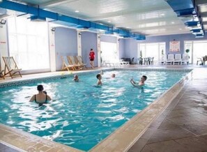 An indoor swimming pool with clear blue water, tiled walls, and a blue ceiling. - Charming Chalet Nestled in Heart of Clarach Bay (Aberystwyth)