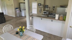 A compact kitchen with white cabinets, a microwave, and a small refrigerator. - Country farm cottage (Nesmith)