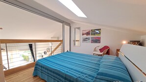 Une chambre avec un grand lit, un balcon et une vue sur l’extérieur.