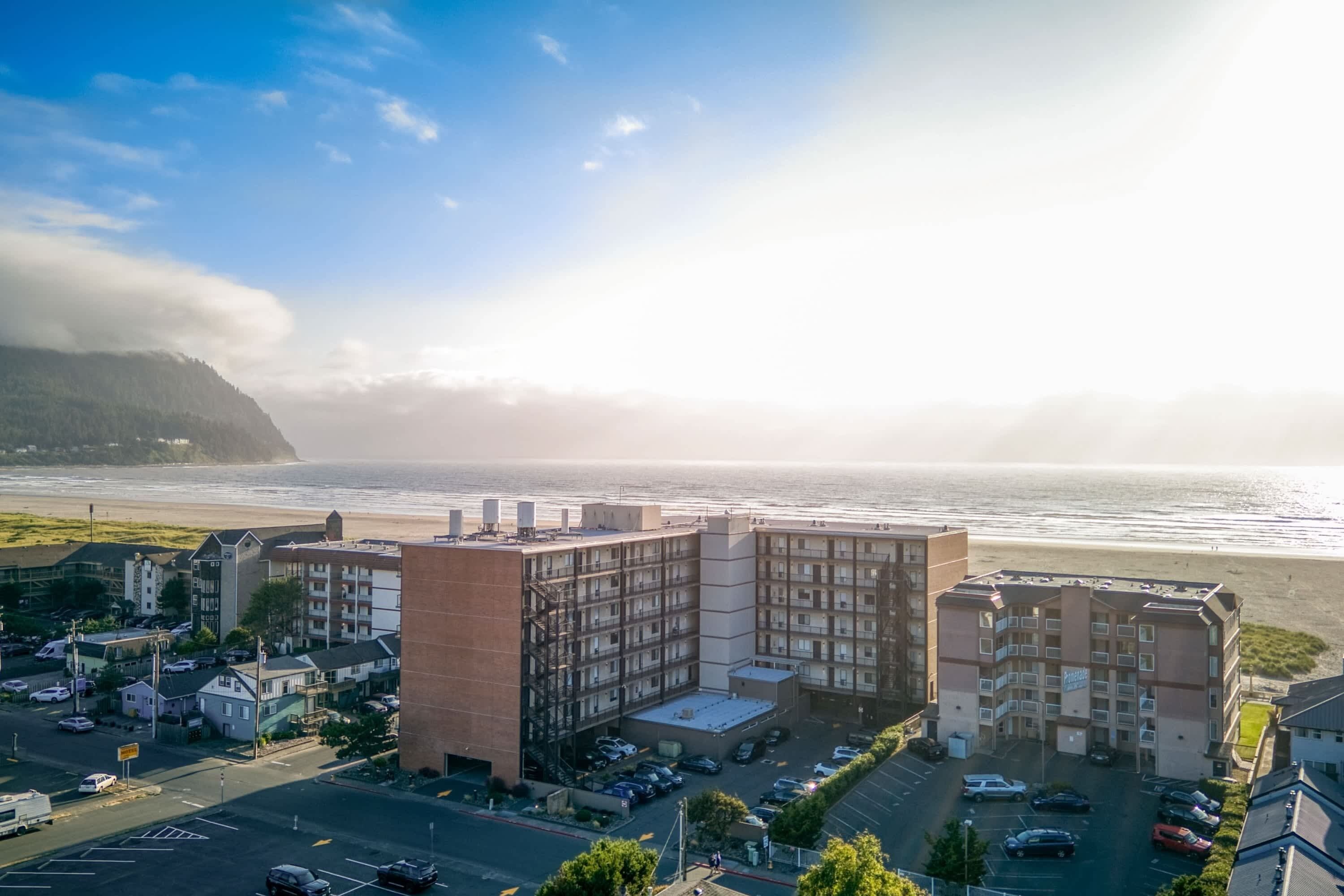 Ein Küstenhotel mit mehreren Gebäuden, einem Parkplatz und Blick auf den Ozean.