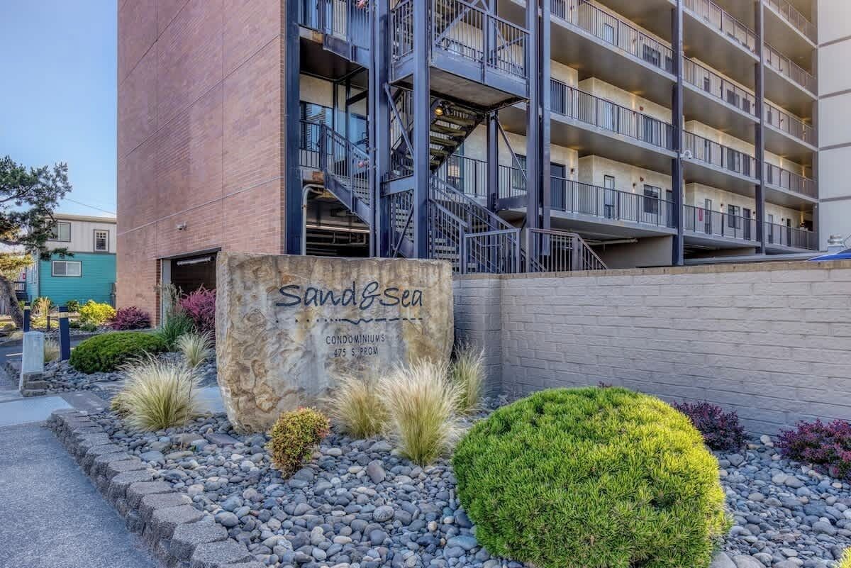 A multi-story building with a sign reading "Sand & Sea Condominiums 425 S. Prom."