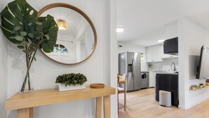 Una cocina moderna con armarios blancos, electrodomésticos de acero inoxidable y suelo de madera.