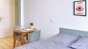 A bedroom with a bed, a bedside table, a chair, and a small table with a plant. - 4-Charming stay in a renovated farmhouse (Saint-Quentin)