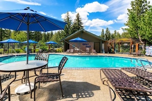 A swimming pool with lounge chairs and umbrellas, a covered seating area, and a sign reading 'Quiet Pool'.