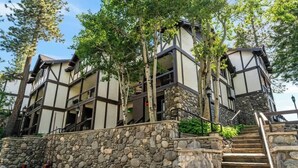 A multi-story building with a stone facade and a staircase leading to the entrance.