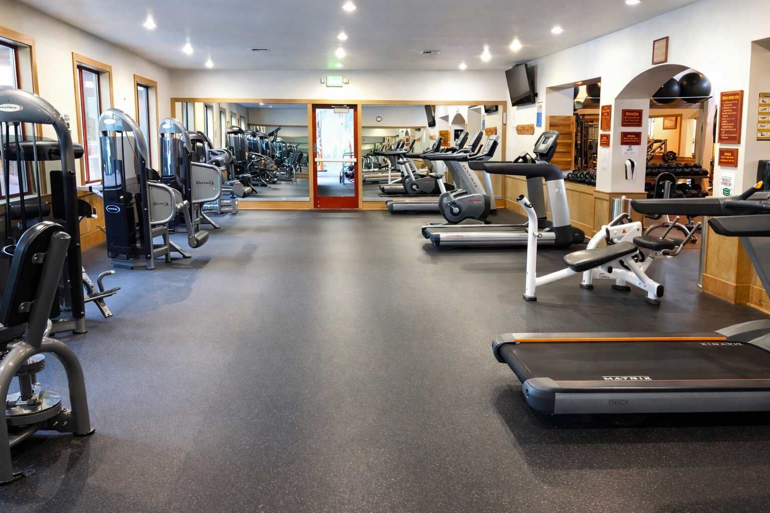 A gym with treadmills, elliptical machines, and weight equipment.