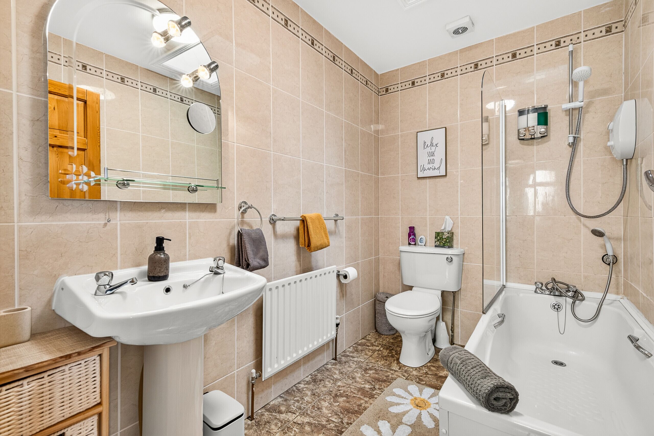 A bathroom with a bathtub, a toilet, a sink, and a mirror.