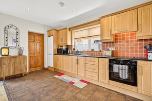 A kitchen with wooden cabinets, a microwave, a stove, and a refrigerator.