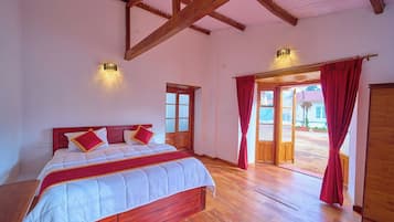 Un dormitorio con cama de madera, una ventana con cortinas y vistas al exterior.