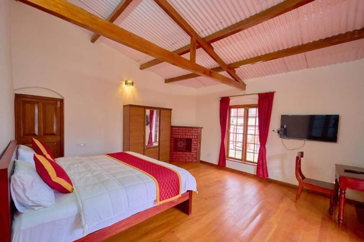 A bedroom with a wooden bed, a TV, and a fireplace.